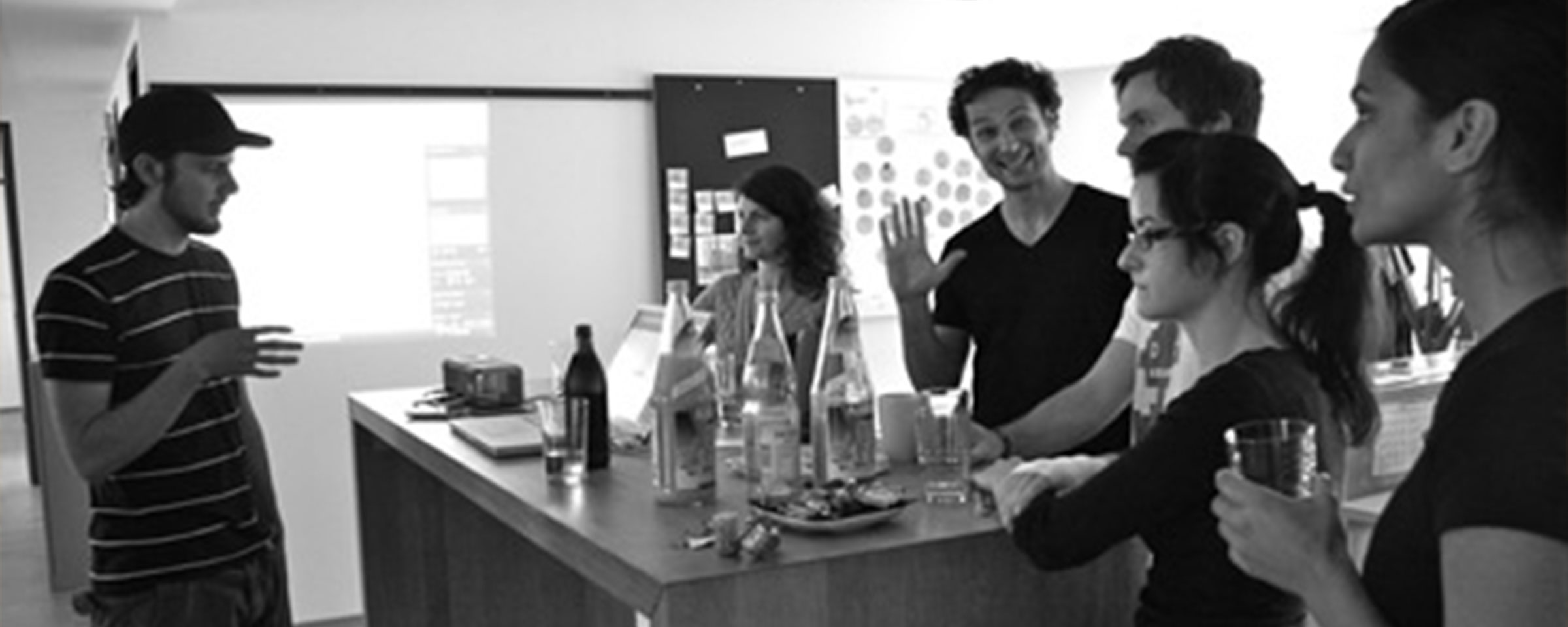 Intuity Mitarbeiter stehen um einen Tisch und unterhalten sich